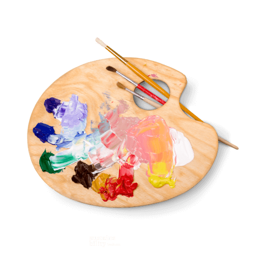 Wooden artist’s palette with colorful paint dabs and three paintbrushes resting on top, displayed on a transparent background